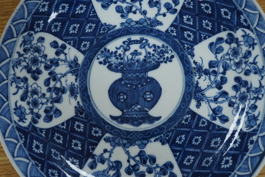 A 19th century Chinese blue and white plate decorated with a flower basket, apocryphal Kangxi four character mark to the base, 25cm in diameter